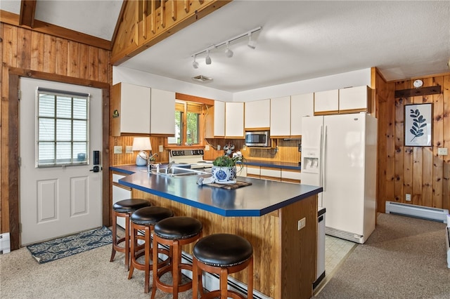 6525 Bonnie Castle Rd, Huron, NY 14590 - kitchen with stainless steel microwave, white refrigerator with ice dispenser, a baseboard heating unit, a sink, and wooden walls