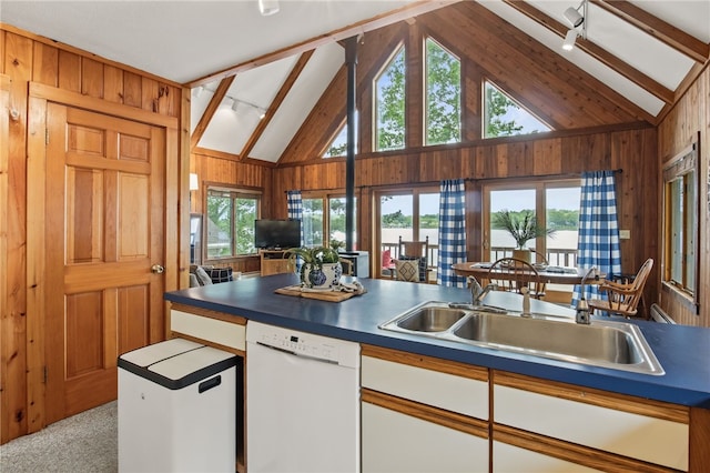 6525 Bonnie Castle Rd, Huron, NY 14590 - kitchen featuring white dishwasher, wooden walls, a sink, white cabinetry, and high vaulted ceiling