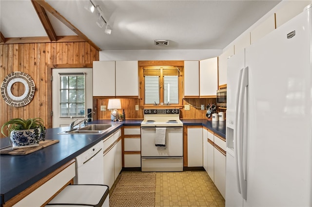 6525 Bonnie Castle Rd, Huron, NY 14590 - kitchen with white appliances, a sink, wooden walls, dark countertops, and white cabinets