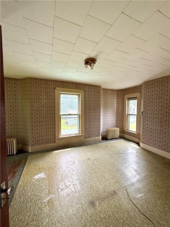 9 Weidman St, Unadilla, NY 13849 - unfurnished room with radiator, wallpapered walls, and baseboards