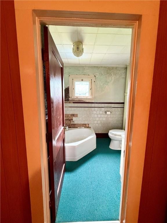 9 Weidman St, Unadilla, NY 13849 - bathroom with toilet, tile patterned floors, wainscoting, and tile walls