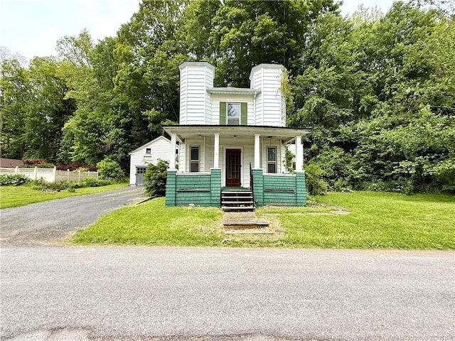 9 Weidman St, Unadilla, NY 13849 - view of front of property featuring covered porch, a chimney, and a front lawn