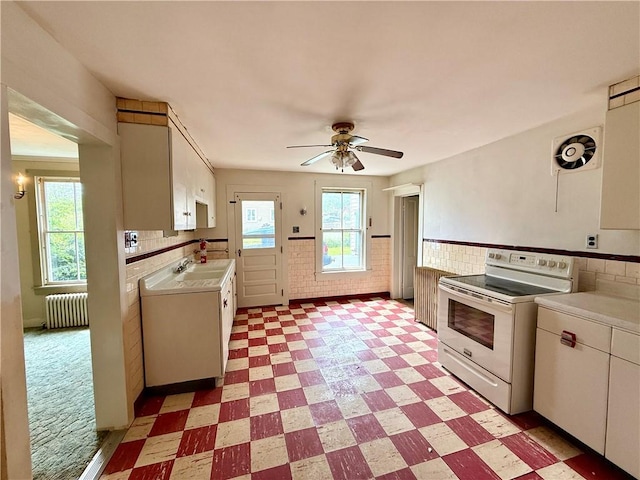 9 Weidman St, Unadilla, NY 13849 - kitchen with electric stove, radiator, light floors, light countertops, and a ceiling fan