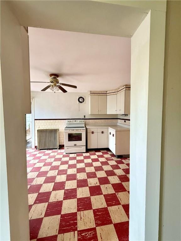 9 Weidman St, Unadilla, NY 13849 - kitchen with white range with electric stovetop, light floors, a ceiling fan, light countertops, and white cabinets