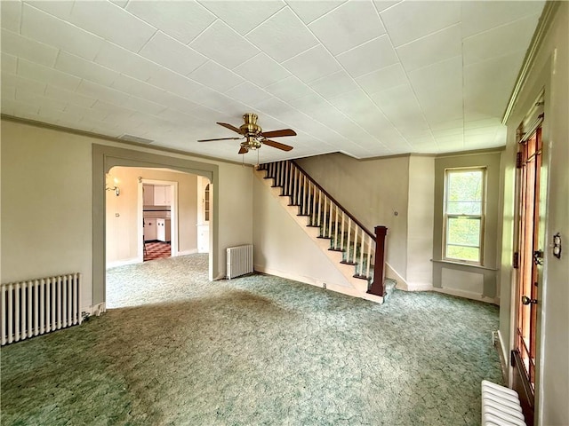 9 Weidman St, Unadilla, NY 13849 - unfurnished living room with radiator heating unit, carpet floors, stairs, and ornamental molding