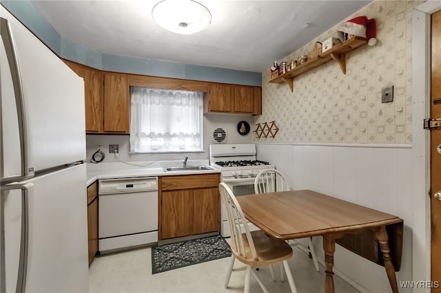 163 Shepard Ave, Tonawanda-Town, NY 14217 - kitchen with white appliances, brown cabinetry, a sink, light countertops, and a wainscoted wall