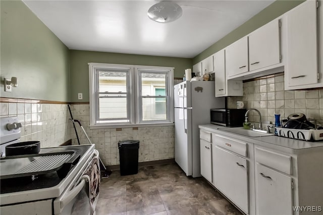 163 Shepard Ave, Tonawanda-Town, NY 14217 - kitchen with black microwave, stove, freestanding refrigerator, a sink, and white cabinets
