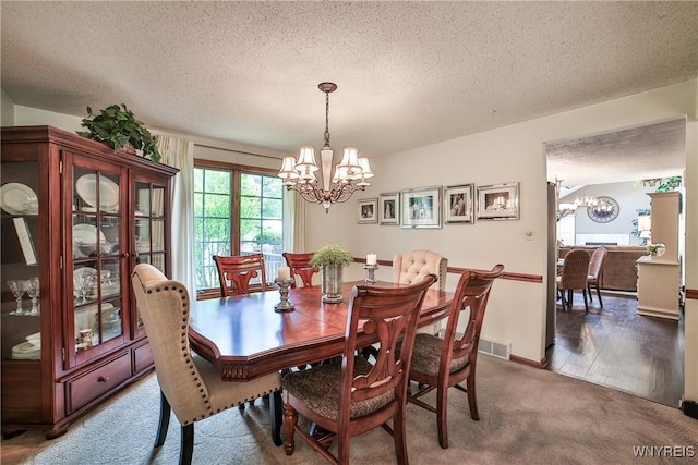 218 Palmdale Dr, Amherst, NY 14221 - dining area featuring a chandelier, a textured ceiling, and carpet flooring