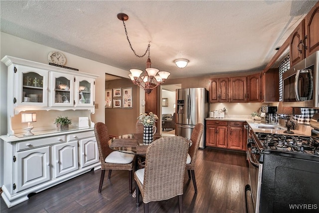 218 Palmdale Dr, Amherst, NY 14221 - kitchen featuring stainless steel appliances, a chandelier, light countertops, dark wood finished floors, and glass insert cabinets