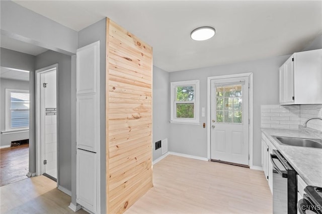 133 Avon Rd, Syracuse, NY 13206 - kitchen with a sink, light countertops, light wood-type flooring, dishwasher, and baseboards