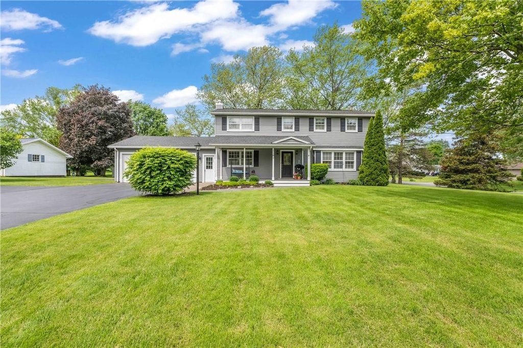 1101 Five Mile Line Rd, Webster, NY 14580 - view of front facade featuring covered porch, driveway, an attached garage, and a front lawn
