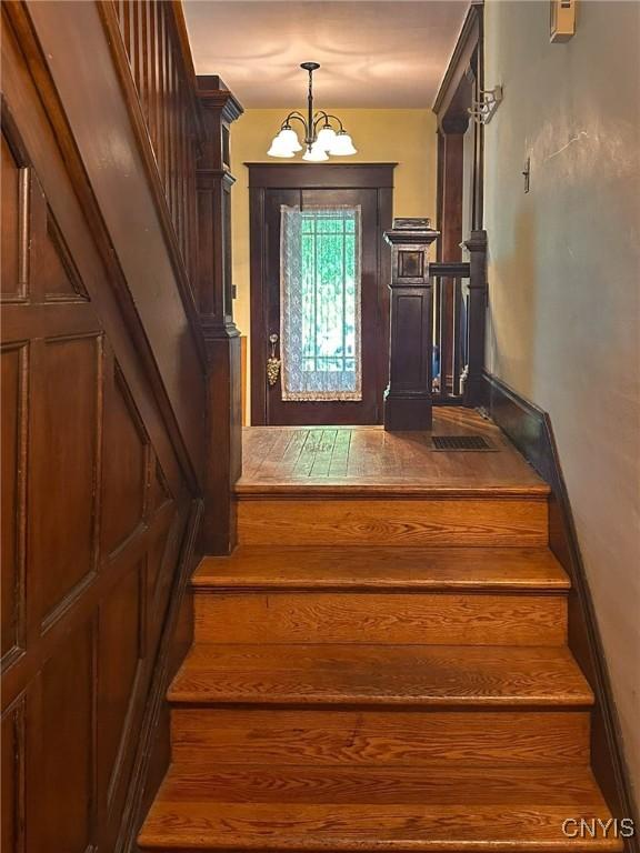 169 Pleasant St, Utica, NY 13501 - stairs featuring a chandelier