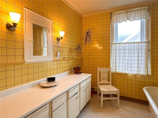 169 Pleasant St, Utica, NY 13501 - bathroom with tile walls, a freestanding tub, vanity, and tile patterned floors