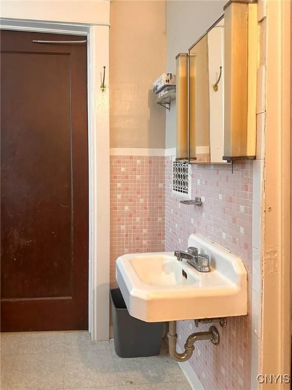 169 Pleasant St, Utica, NY 13501 - bathroom with a sink, tile patterned flooring, and wainscoting