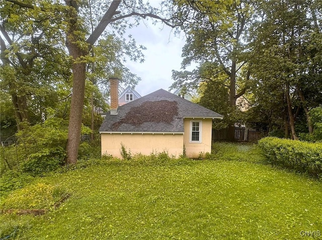 169 Pleasant St, Utica, NY 13501 - view of side of home featuring roof with shingles and a chimney