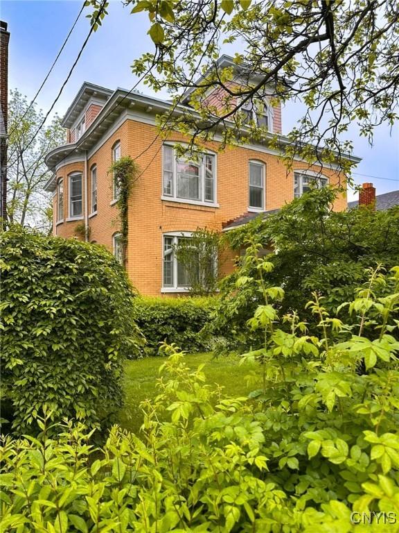 169 Pleasant St, Utica, NY 13501 - view of property exterior with brick siding and a chimney