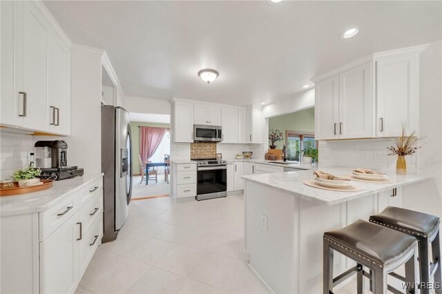 6157 Walnut Creek Ct, Clarence, NY 14051 - kitchen with stainless steel appliances, decorative backsplash, plenty of natural light, a peninsula, and recessed lighting