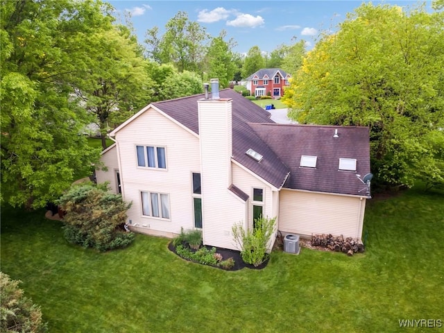 6157 Walnut Creek Ct, Clarence, NY 14051 - rear view of house with a chimney, a lawn, view of wooded area, and central AC unit