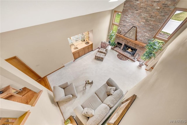 6157 Walnut Creek Ct, Clarence, NY 14051 - living area with high vaulted ceiling, a fireplace, plenty of natural light, and brick wall