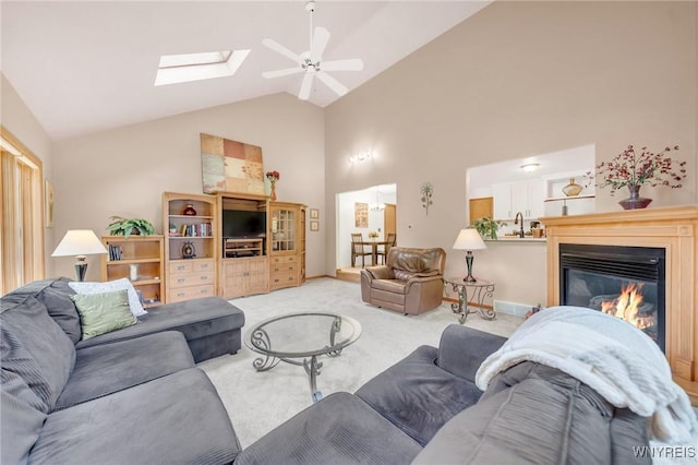 6157 Walnut Creek Ct, Clarence, NY 14051 - carpeted living area with high vaulted ceiling, ceiling fan, a skylight, and a glass covered fireplace