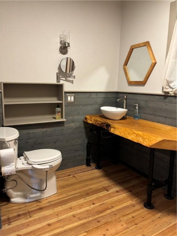 6940 County Highway 18, Plainfield, NY 13491 - bathroom featuring a wainscoted wall, hardwood / wood-style flooring, toilet, wooden walls, and vanity