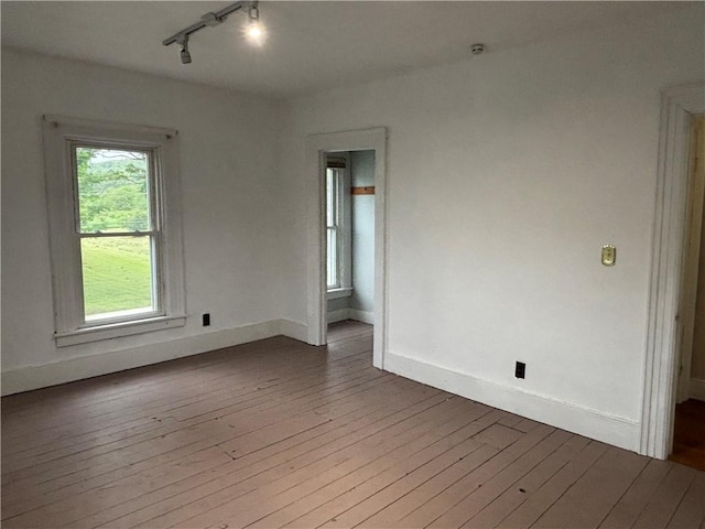 6940 County Highway 18, Plainfield, NY 13491 - empty room with wood-type flooring, rail lighting, plenty of natural light, and baseboards