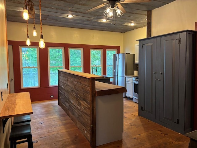 6940 County Highway 18, Plainfield, NY 13491 - kitchen featuring a ceiling fan, plenty of natural light, hardwood / wood-style flooring, and a kitchen island
