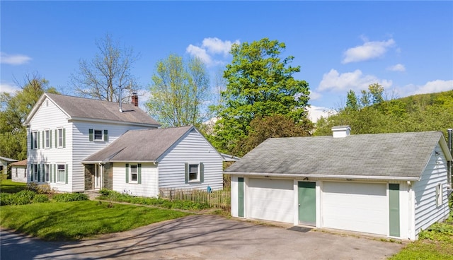 6940 County Highway 18, Plainfield, NY 13491 - view of front of house with a chimney, roof with shingles, a detached garage, and an outbuilding