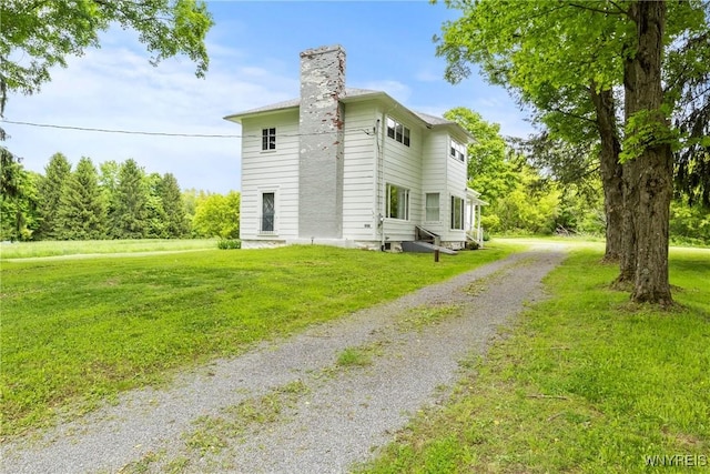 1822 Grover Rd, Aurora, NY 14052 - view of home's exterior with driveway, a chimney, and a lawn