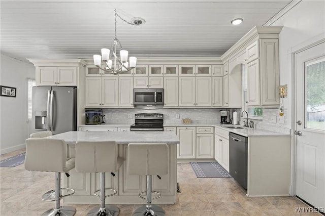 1822 Grover Rd, Aurora, NY 14052 - kitchen featuring stainless steel appliances, a chandelier, a sink, a kitchen bar, and a center island