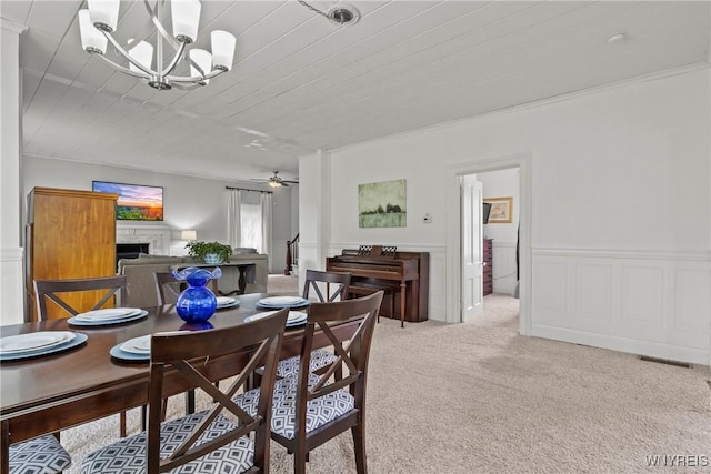 1822 Grover Rd, Aurora, NY 14052 - dining area featuring a chandelier, light colored carpet, a fireplace, wooden ceiling, and wainscoting