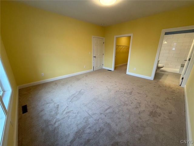 10 Platten Dr, Elbridge, NY 13080 - unfurnished bedroom featuring carpet flooring, baseboards, connected bathroom, and a walk in closet