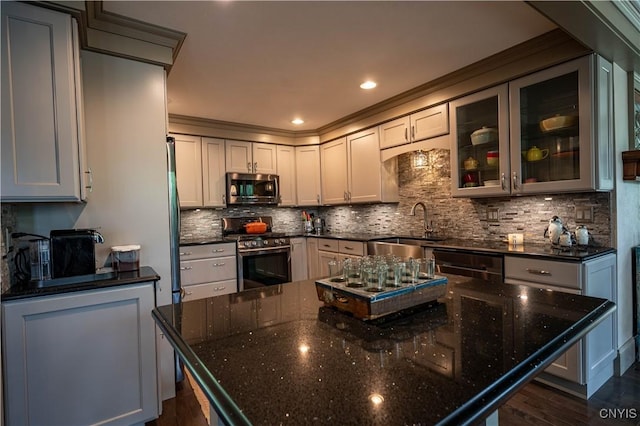 161 Portaferry Lake Dr, Pitcairn, NY 13648 - kitchen with appliances with stainless steel finishes, a center island, a sink, dark wood finished floors, and decorative backsplash