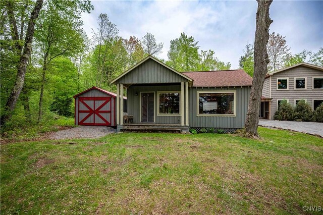 161 Portaferry Lake Dr, Pitcairn, NY 13648 - view of front of house featuring a front lawn, roof with shingles, a porch, and board and batten siding