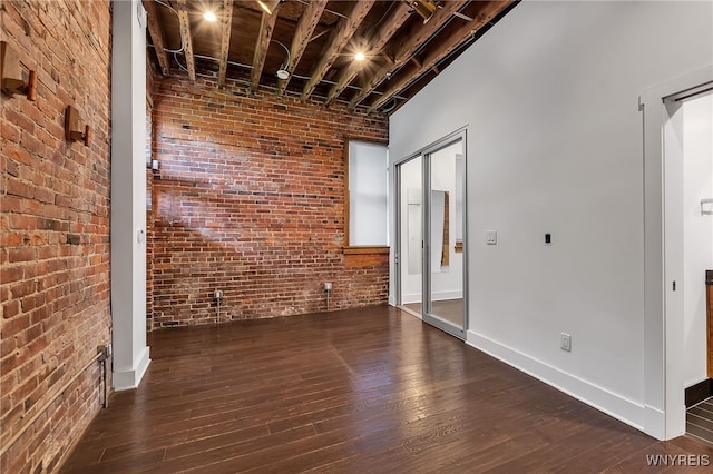 871 Seneca St, Buffalo, NY 14210 - spare room featuring brick wall, hardwood / wood-style flooring, and baseboards
