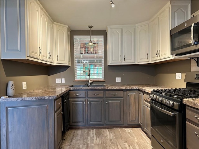 19 Hickory St, Hanover, NY 14136 - kitchen with gas range oven, stainless steel microwave, a sink, and white cabinetry