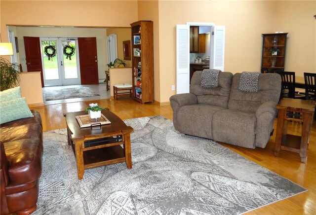 1737 Genesee Rd, Elmira, NY 14905 - living room with wood finished floors, french doors, and a baseboard radiator