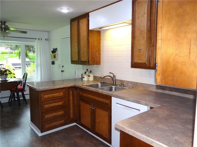 1737 Genesee Rd, Elmira, NY 14905 - kitchen featuring a sink, a peninsula, brown cabinets, a ceiling fan, and tasteful backsplash