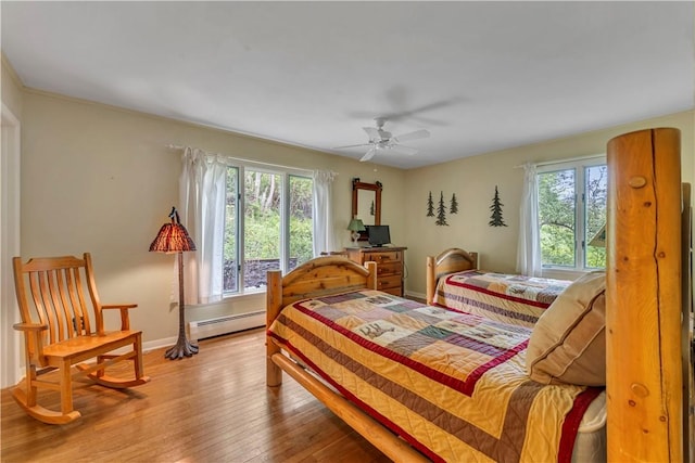 63 Lakeview Dr N, Middlefield, NY 13326 - bedroom with baseboard heating, wood-type flooring, baseboards, and a ceiling fan