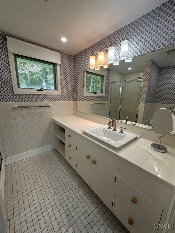 2089 Spring St, Hamilton, NY 13346 - bathroom featuring tile walls, a shower stall, vanity, wallpapered walls, and tile patterned floors