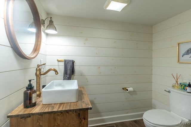 207 Twin Hills Dr, Syracuse, NY 13207 - bathroom featuring toilet, vanity, wood finished floors, and wood walls