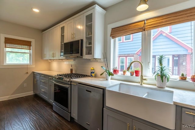 207 Twin Hills Dr, Syracuse, NY 13207 - kitchen with appliances with stainless steel finishes, a sink, baseboards, glass insert cabinets, and decorative backsplash