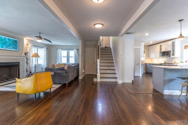 207 Twin Hills Dr, Syracuse, NY 13207 - living area featuring dark wood finished floors, stairway, baseboards, and ceiling fan