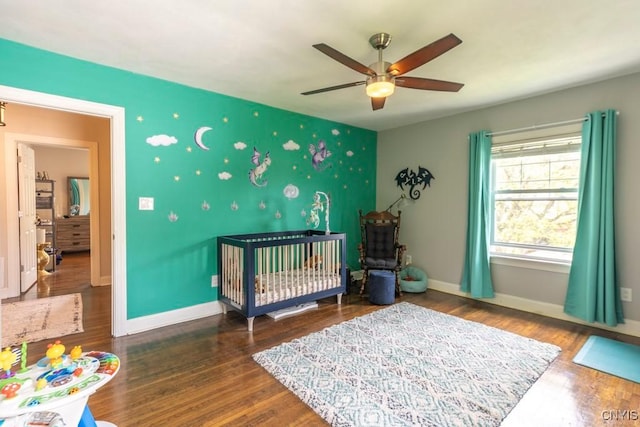 207 Twin Hills Dr, Syracuse, NY 13207 - bedroom with a nursery area, wood finished floors, baseboards, an accent wall, and a ceiling fan