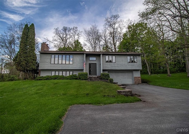 6010 E Lake Rd, Sullivan, NY 13035 - bi-level home with a chimney, a garage, asphalt driveway, entry steps, and a front yard