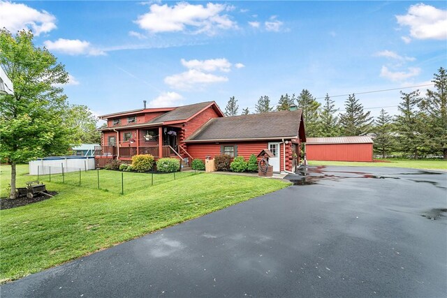 8311 State Route 415, Campbell, NY 14821 - log home with a front lawn, roof with shingles, a wooden deck, asphalt driveway, and log siding