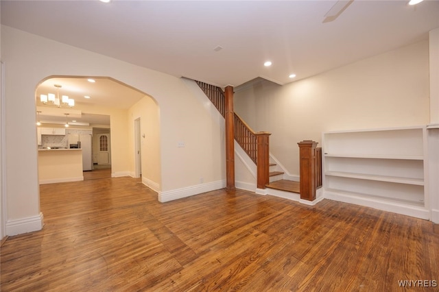 445 Connecticut St, Buffalo, NY 14213 - unfurnished living room featuring arched walkways, wood finished floors, recessed lighting, stairway, and baseboards