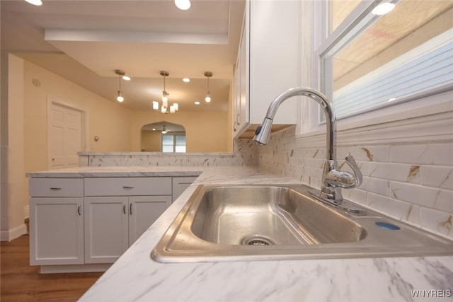 445 Connecticut St, Buffalo, NY 14213 - kitchen with a sink, backsplash, a peninsula, pendant lighting, and white cabinets