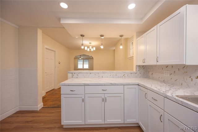 445 Connecticut St, Buffalo, NY 14213 - kitchen featuring a peninsula, white cabinets, wood finished floors, hanging light fixtures, and light stone countertops