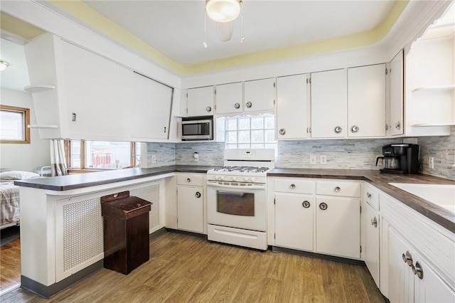 40 Mcnaughton St, Rochester, NY 14606 - kitchen featuring white range with gas cooktop, stainless steel microwave, dark countertops, and white cabinets
